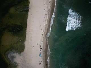 Aerial shot of the beach with the waves of water crashing on the shore, Los angeles, Malibu