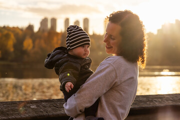Mother with Baby Boy at Deer Lake. Burnaby, BC Canada. Sunny Sunset - obrazy, fototapety, plakaty