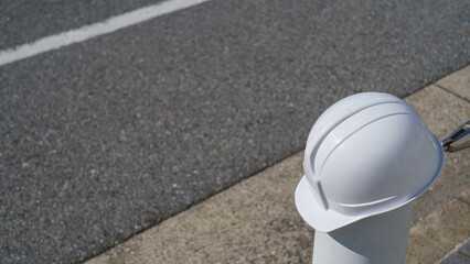 アスファルト舗装の道路とヘルメット　建設業・舗装工事などのイメージ