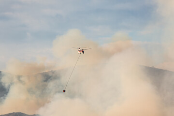 Helicopters dropping water on a wildfire in California