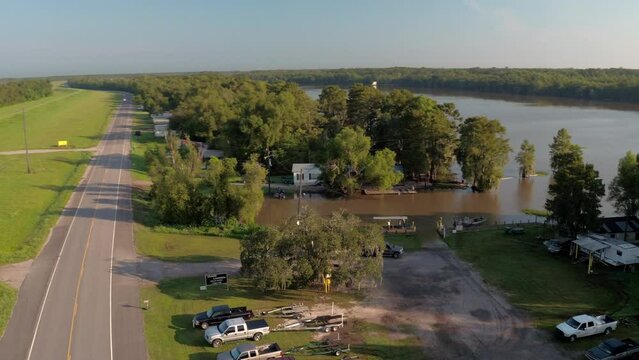 Aerial Panning Shot Of Pickup Truck Pulling Old Boat By River Against Clear Sky On Sunny Day - Bayou, Louisiana
