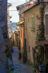 Fototapeta na wymiar Vertical shot of a narrow paved street passing through old medieval residential buildings in Italy