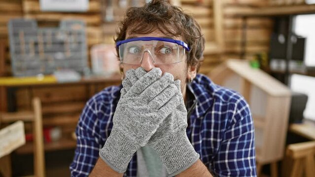Shocked young carpenter covering mouth with hands in regret over careless mistake, secret blunder at carpentry workshop revealed!