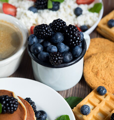 Cup with berries, pancakes and coffee. Have a good morning tomorrow.