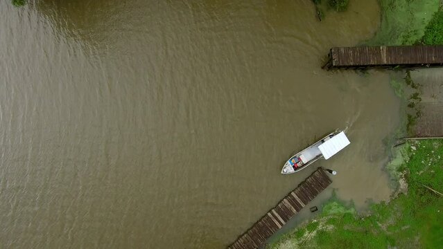 Aerial Top Lockdown Shot Of Motorboat Moving In Rippled River - Bayou, Louisiana