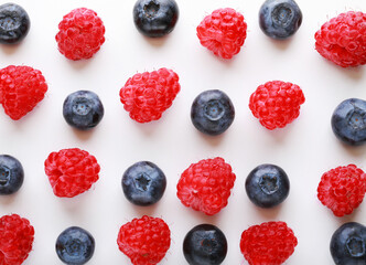 Raspberry and blueberrys on white background. Food background.