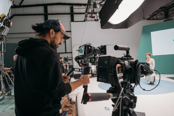 Director of photography with a camera in his hands on the set. Professional videographer at work on filming a movie