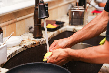 hand-washing dishes, symbolizing equality and shared responsibilities of men and women gender roles responsibilities. Hand washing vs dishwasher technological advances 