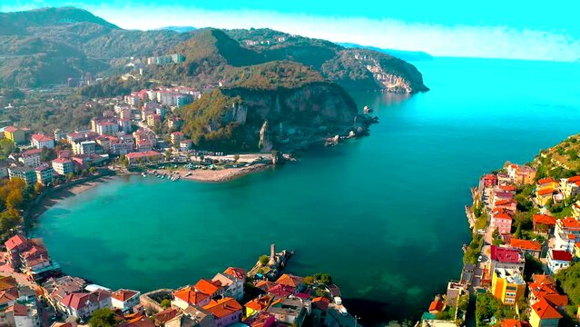 City view in the mountains of Amasra. Drone approaches beautiful landscape. Aerial view of houses and deep blue sea.