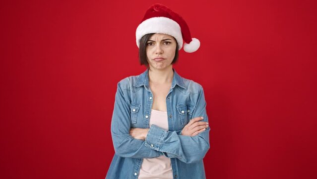 Young caucasian woman wearing christmas hat saying no with head over isolated red background
