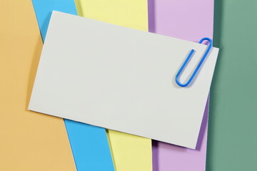 blank white card paper note or notepad isolated with clip pin on multi color paper background
