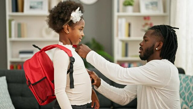 African american father and daughter preparing to go to school high five hugging at home