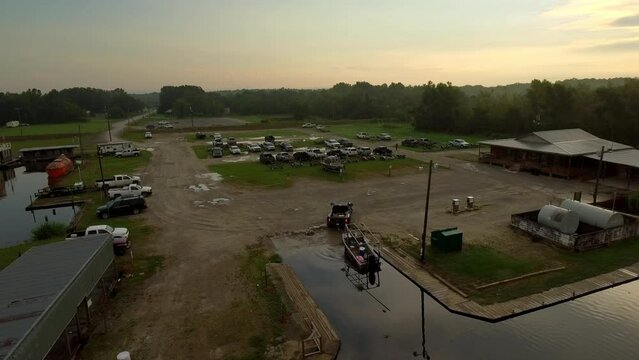 Aerial Lockdown Shot Of Pickup Truck Pushing Boat In River During Sunset - Bayou, Louisiana