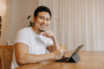 Happy smile freelance asian man work in the cafe.