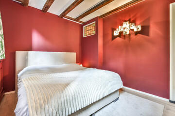 a bed in a room with red walls and wood beams on the ceiling above it is an image of a bedroom