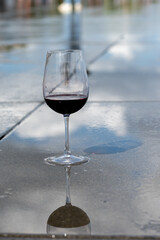 Tasting of Bordeaux blended red wine with wine city Bordeaux on background, left bank of Gironde Estuary, France. Glass of red French wine.