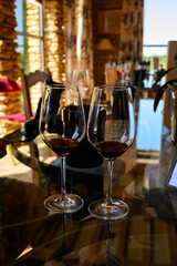 Tasting of red dry wine in Chateauneuf-du-Pape wine making village in France with green vineyards on large pebbles galets and sandstone clay soil