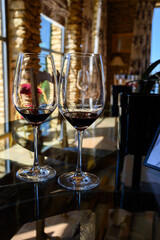 Tasting of red dry wine in Chateauneuf-du-Pape wine making village in France with green vineyards on large pebbles galets and sandstone clay soil