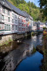 View of houses and streets of old colourful German town Monschau in bend of the river and hidden between the hills, Eifel national park, Germany