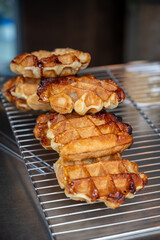 Eating of fresh baked hot Belgian sugar waffles, street food in Bruges
