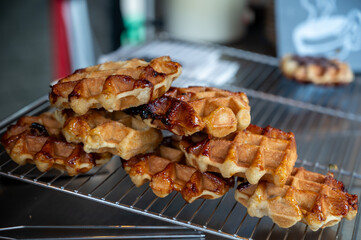 Eating of fresh baked hot Belgian sugar waffles, street food in Bruges