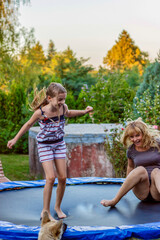 Fototapeta na wymiar Mother and her daughter jumping high having lots of fun