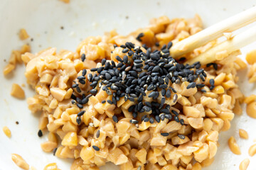 ひきわり納豆と黒ごまを箸で混ぜ合わせる。

