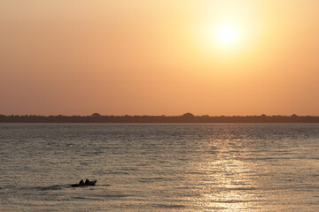 Amazonian fishermen's small boats drifting on a river at sunset © Tarcisio Schnaider