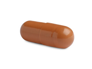 One brown pill on white background. Medicinal treatment