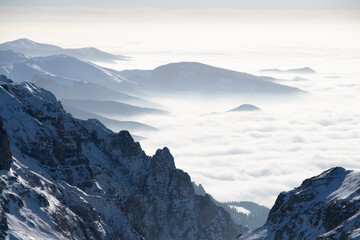 A majestic range of snow-capped peaks concealed amongst billowing clouds