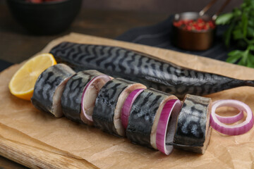 Tasty salted mackerel, onion and lemon on parchment, closeup