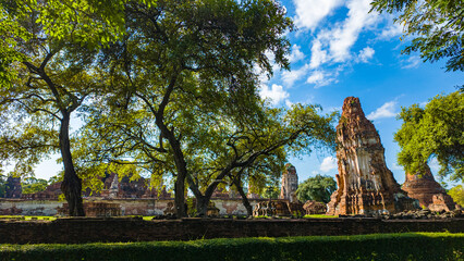 Fototapeta na wymiar Ruins of an old brick wall at the Religious Historical Park..Wat Phra Ram in the Ayutthaya period was the capital..scenery sunrise white cloud in blue sky .It's like being in a historical era
