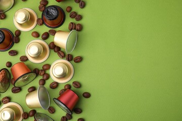 Many coffee capsules and beans on green background, flat lay. Space for text