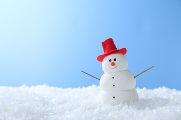 Funny snowman on snow against light blue background, space for text