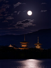 池に光が反射する満月とライトアップされた薬師寺三重の塔