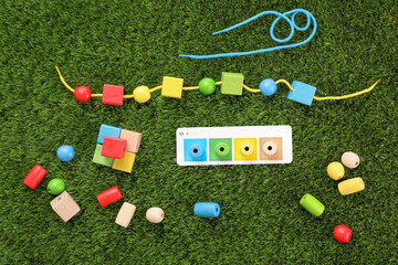 Naklejka premium Educational toy for motor skills development on artificial grass, flat lay