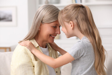 Happy grandmother with her granddaughter at home