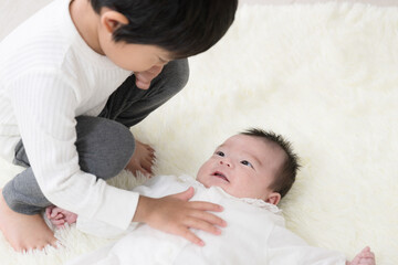 赤ちゃんをかわいがる素敵なお兄ちゃんの俯瞰　兄弟のイメージ