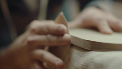 Hands of artisan polishing wooden board with sand paper, sawdust flying around in the air. Close-up shot - Powered by Adobe