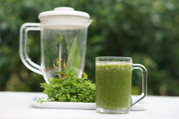 Green smoothie herbal vegetables in glass, outdoor background. Concept, healthy beverage for...