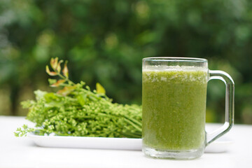 Green smoothie organic herbal vegetables in glass, outdoor background. Concept, healthy beverage...