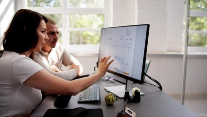 Business People Calculating Tax Together At Desk