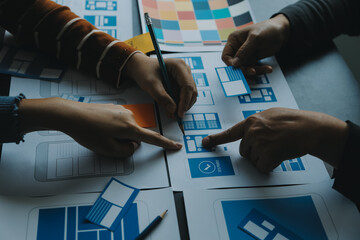 Close up ux developer and ui designer brainstorming about mobile app interface wireframe design on...
