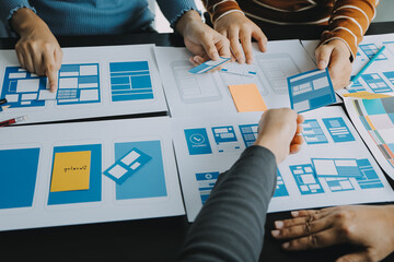Close up ux developer and ui designer brainstorming about mobile app interface wireframe design on...