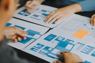 Close up ux developer and ui designer brainstorming about mobile app interface wireframe design on...