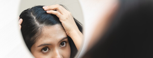 woman looking mirror to find hair problem