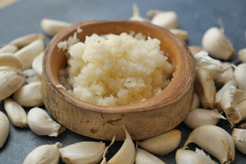 close up of minced garlic on a wooden spoon 