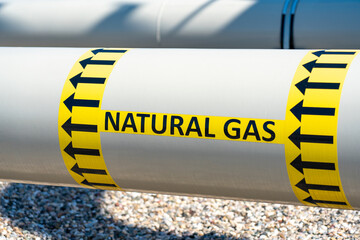 Gray gas pipeline pipe with background of various equipment and inscription