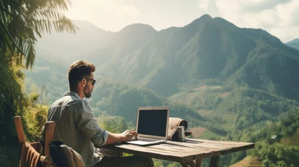 Foto op Canvas A freelance using laptop in nature with beautiful mountain view, concept of digital nomad working on the go concept. © tong2530