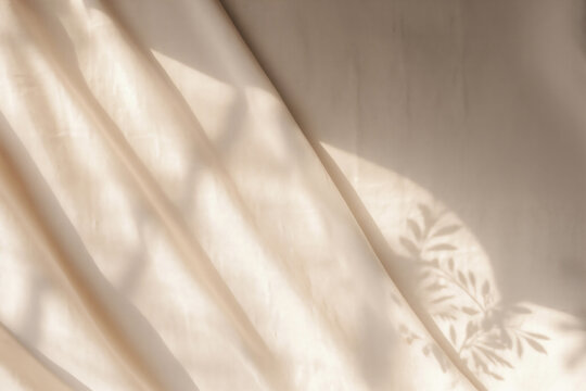 Beige linen fabric texture with folds and natural floral sunlight and leaves shadows. High quality photo